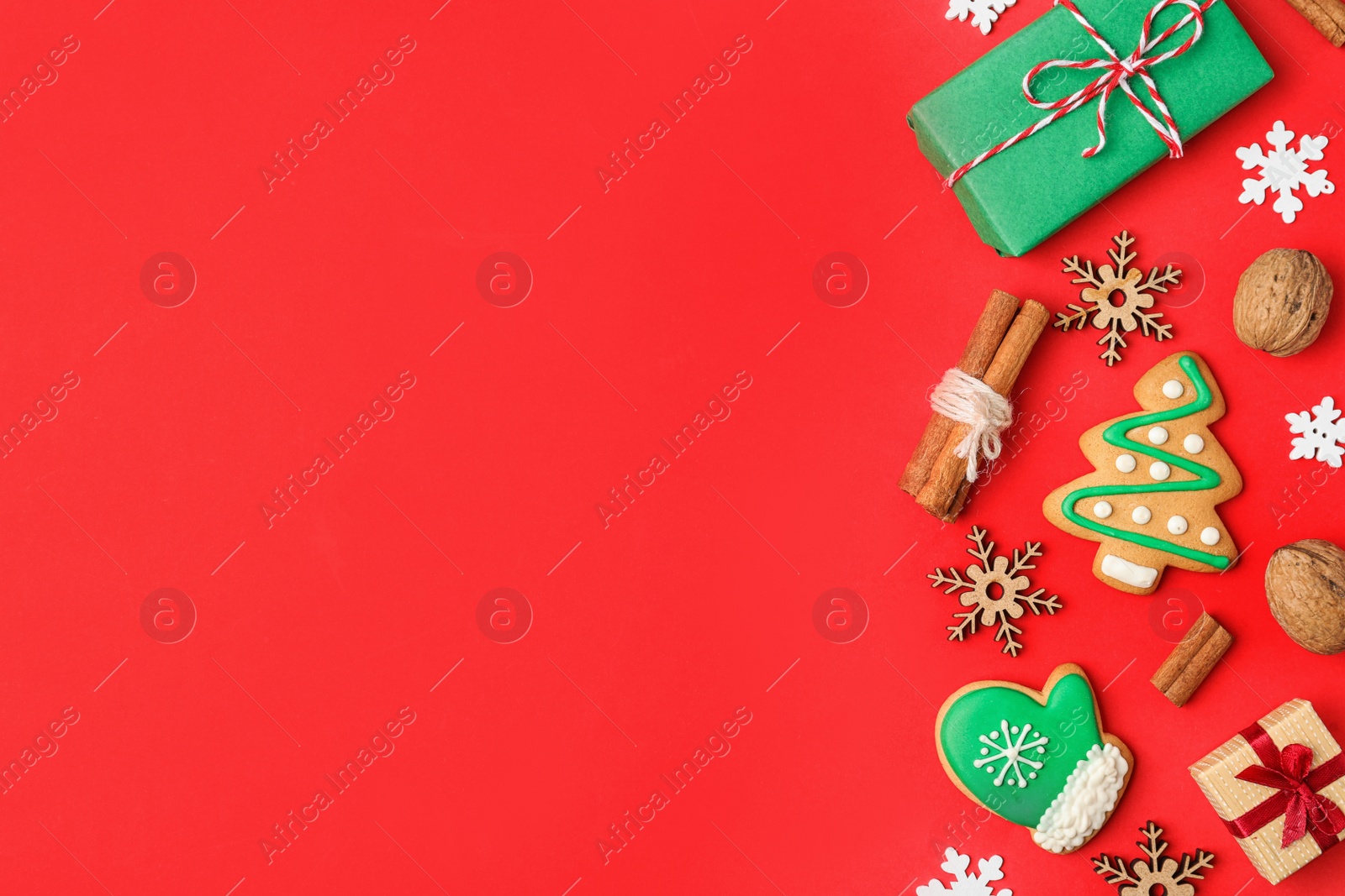 Photo of Flat lay composition with Christmas decorations and treats on red background, space for text. Winter holidays