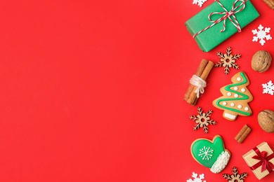 Flat lay composition with Christmas decorations and treats on red background, space for text. Winter holidays