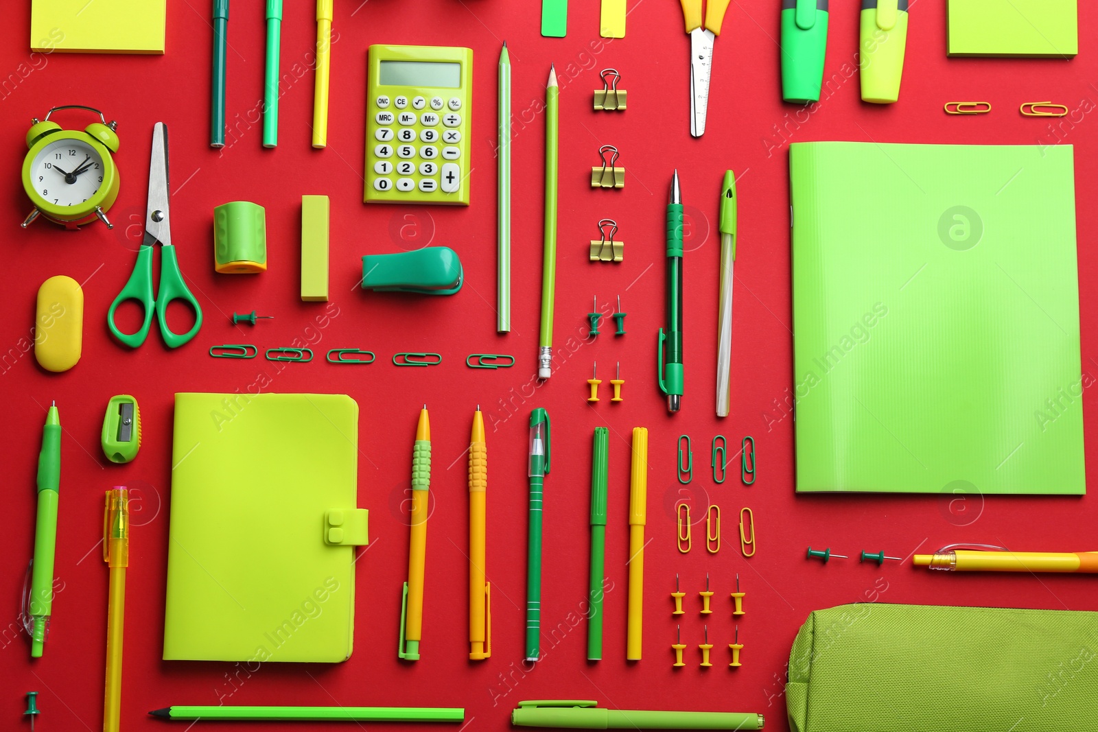 Photo of Green school stationery on red background, flat lay