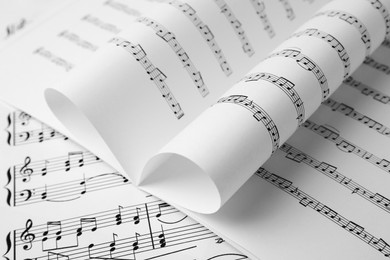 Sheets of paper with music notes as background, closeup