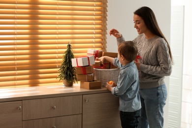 Photo of Mother and son with Christmas gifts at home. Advent calendar in basket