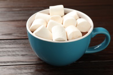 Photo of Tasty hot chocolate with marshmallows on wooden table, closeup