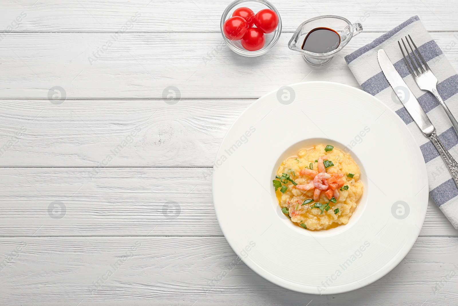 Photo of Plate with tasty shrimps and grits on table, top view