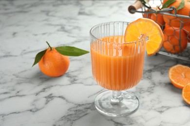 Delicious tangerine liqueur in glass and fresh fruits on white marble table, space for text
