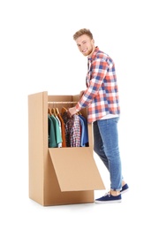 Photo of Young man near wardrobe box on white background