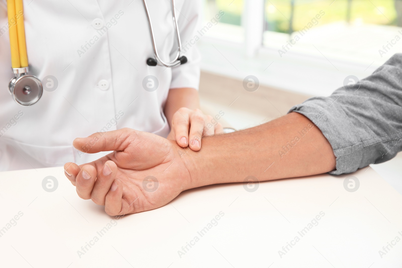 Photo of Doctor checking senior man's pulse in hospital