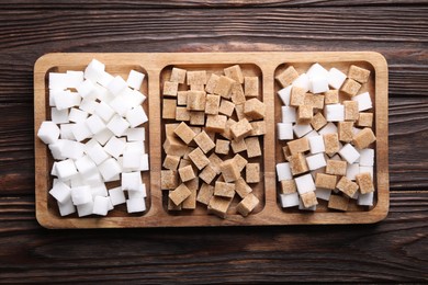 Tray with brown and white sugar cubes on wooden table, top view