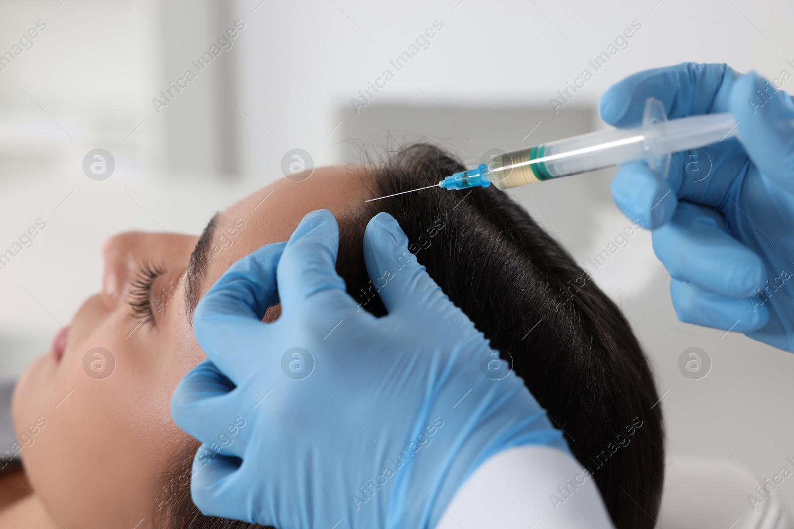 Photo of Trichologist giving injection to patient in clinic, closeup