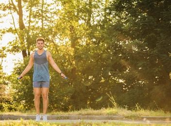 Young man training with jump rope in park