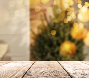 Image of Empty wooden surface and blurred view of Christmas tree in room, space for text. Interior design