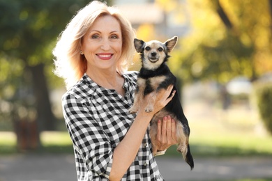 Beautiful mature woman with cute dog in park