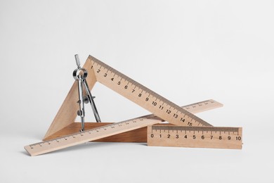 Photo of Different rulers and compass on white background
