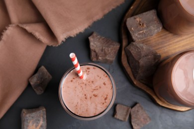 Photo of Delicious chocolate milk on black table, flat lay
