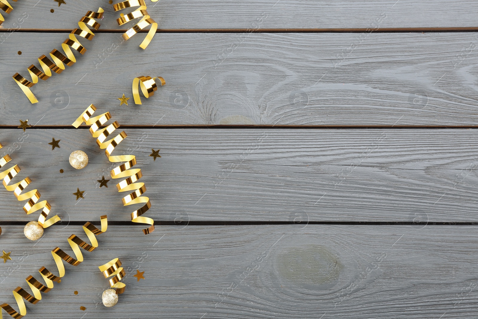 Photo of Flat lay composition with serpentine streamers on grey wooden background, space for text