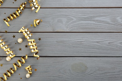 Flat lay composition with serpentine streamers on grey wooden background, space for text