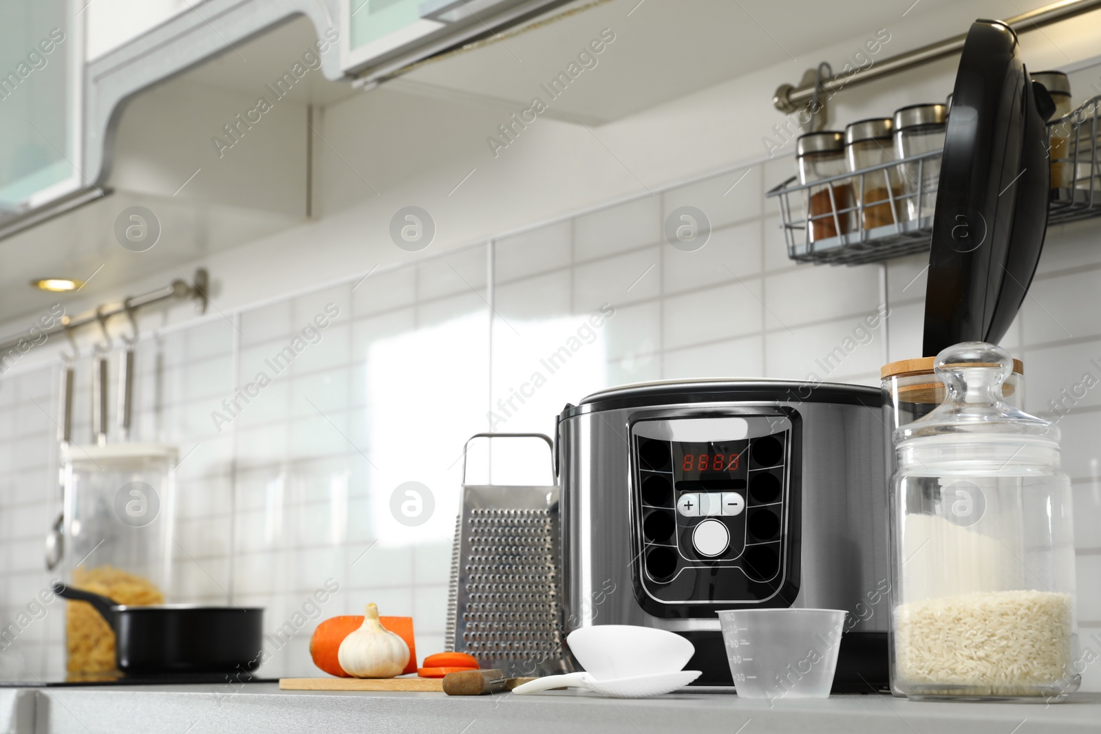 Photo of Modern multi cooker and products on table in kitchen. Space for text