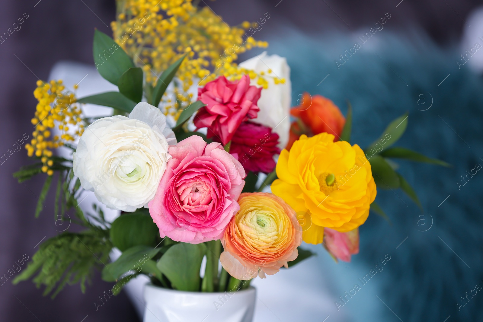 Photo of Vase with beautiful ranunculus flowers on blurred background