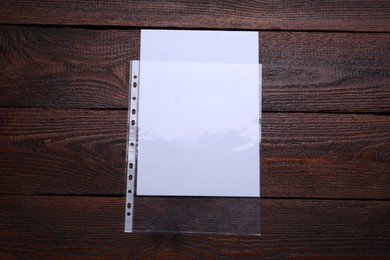 Punched pocket with paper sheet on wooden table, top view