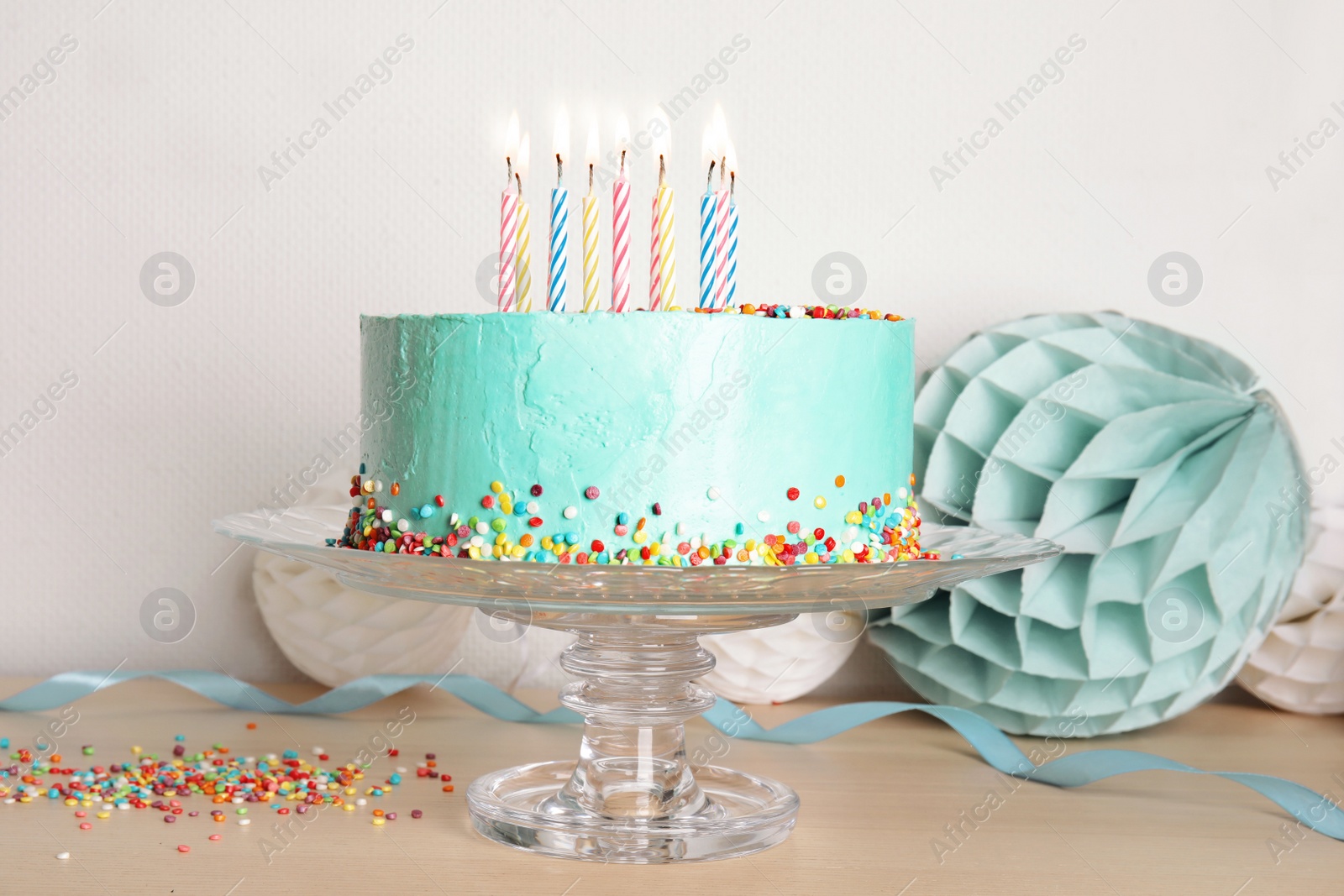 Photo of Stand with fresh delicious cake and birthday decorations on table