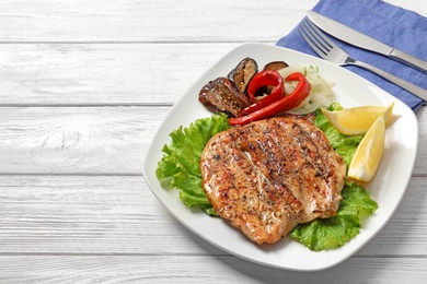 Photo of Plate with tasty grilled meat and vegetables on table