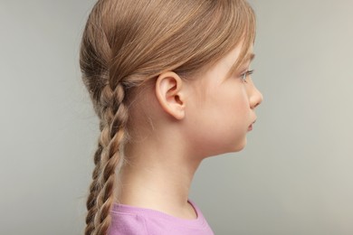 Photo of Hearing problem. Little girl on grey background