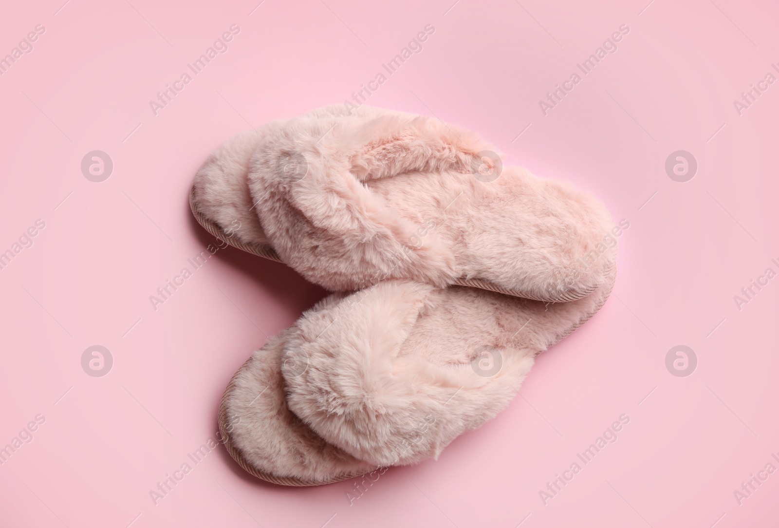 Photo of Pair of stylish soft slippers on pink background, flat lay