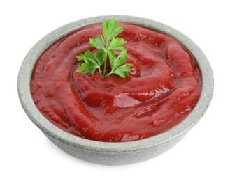 Photo of Tasty ketchup with parsley in bowl isolated on white. Tomato sauce