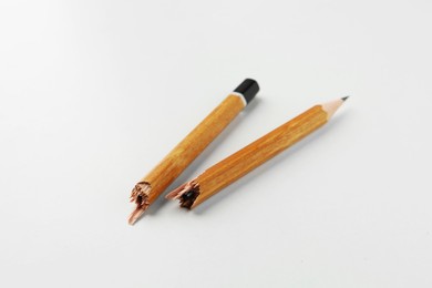 One broken graphite pencil on white background, closeup