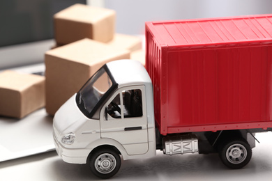 Photo of Toy truck near laptop on table. Logistics and wholesale concept