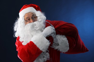 Merry Christmas. Santa Claus with bag on dark blue background
