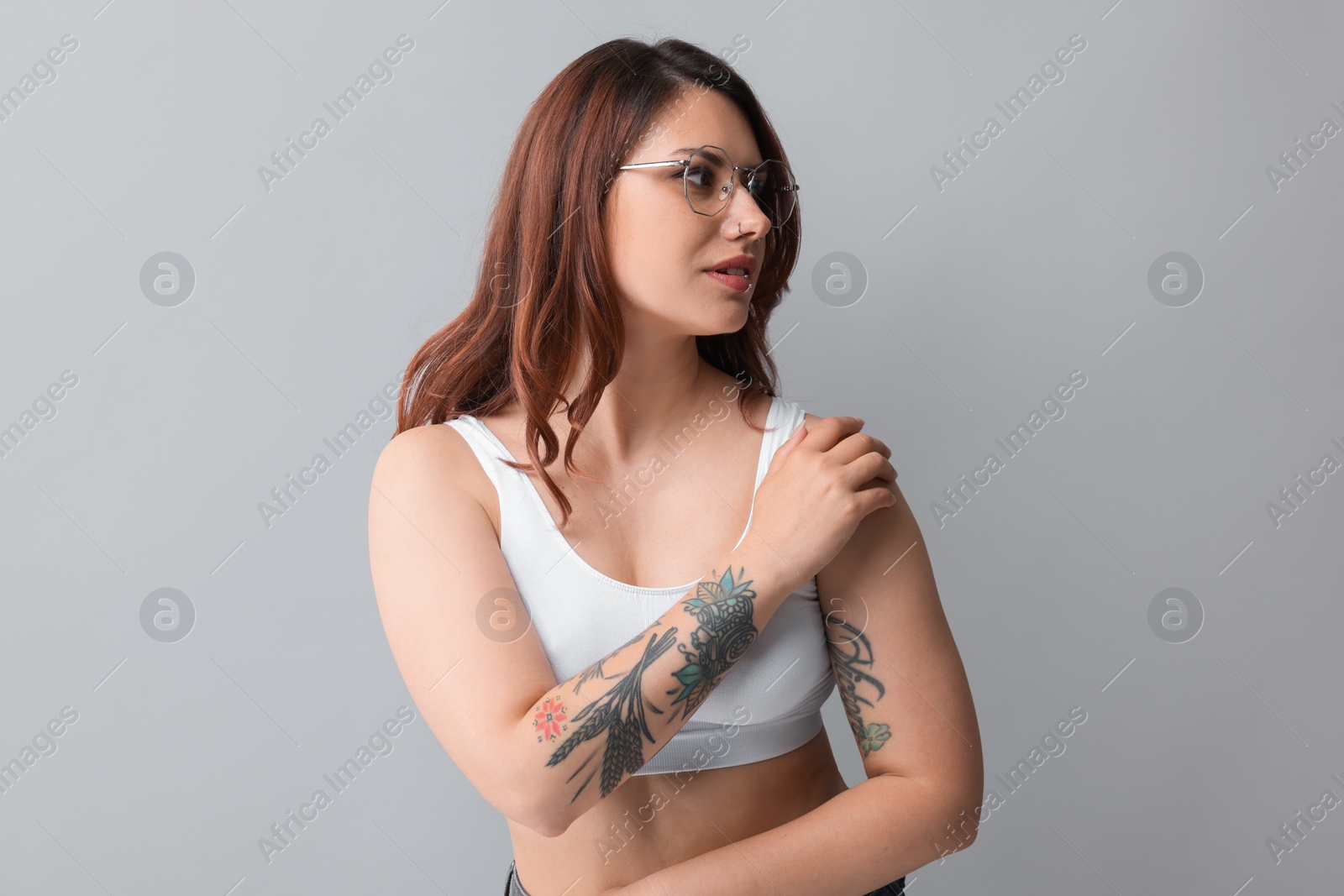 Photo of Portrait of beautiful tattooed woman on gray background