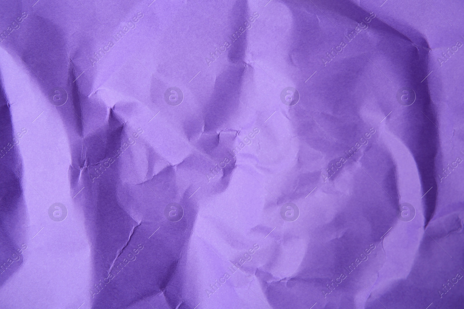 Photo of Sheet of crumpled violet paper as background, top view