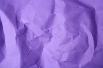 Sheet of crumpled violet paper as background, top view