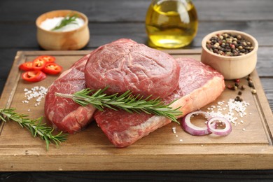 Pieces of raw beef meat and spices on table, closeup