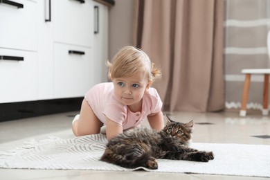 Cute little child with adorable pet on floor at home