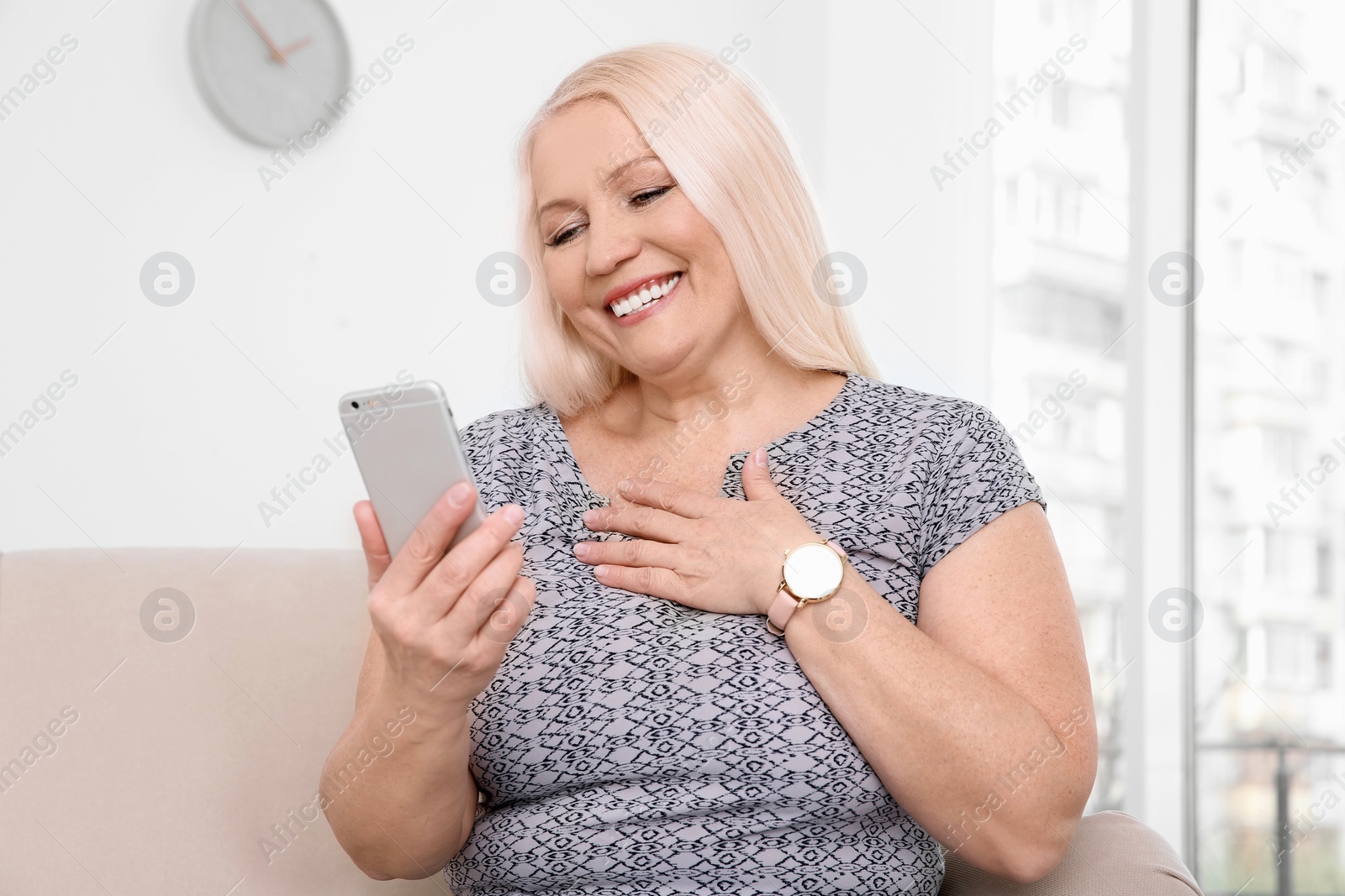 Photo of Mature woman using mobile phone at home