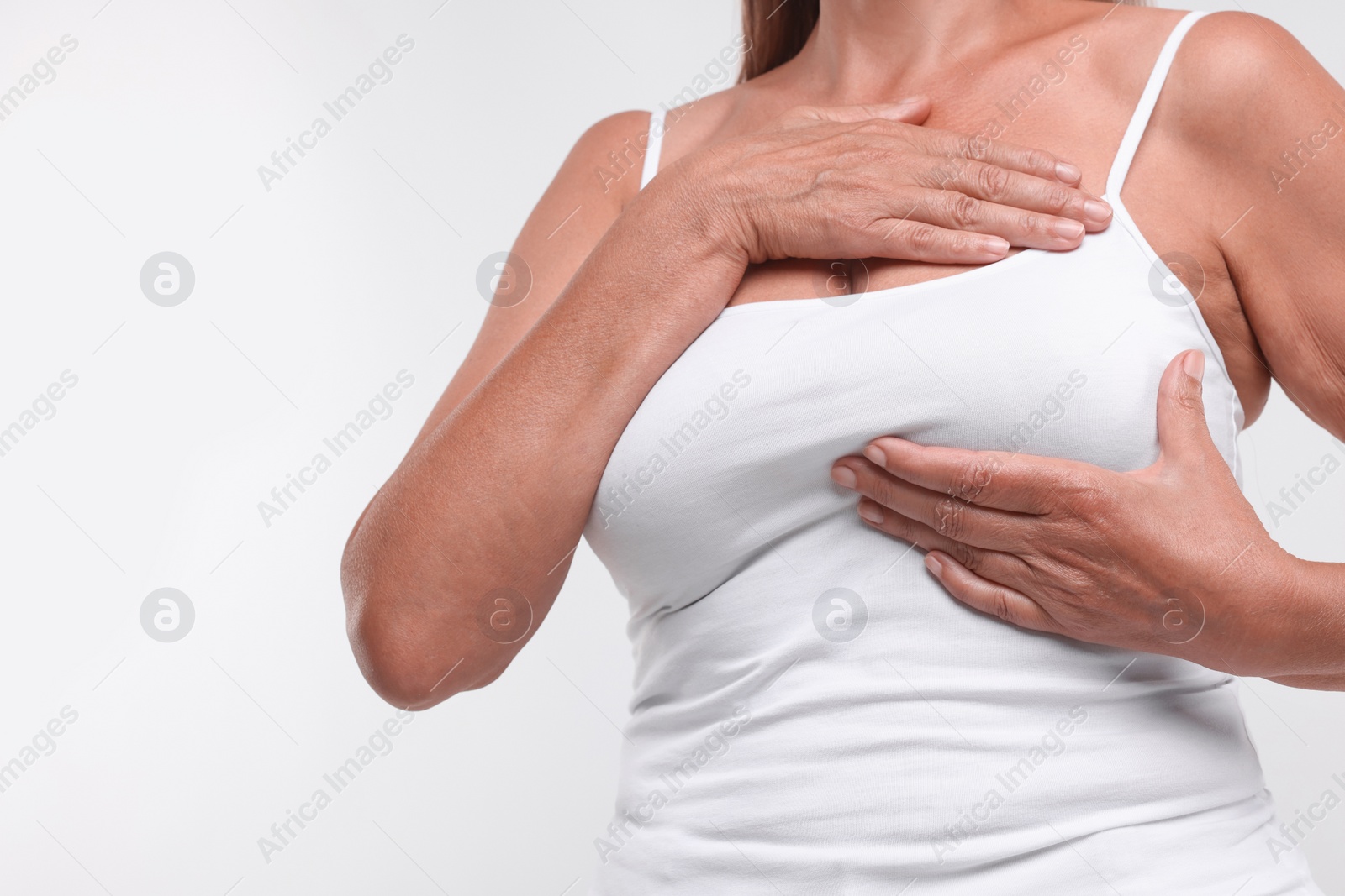 Photo of Woman doing breast self-examination on white background, closeup. Space for text