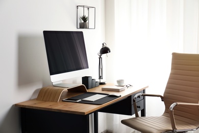 Stylish workplace interior with modern computer on table. Mockup for design