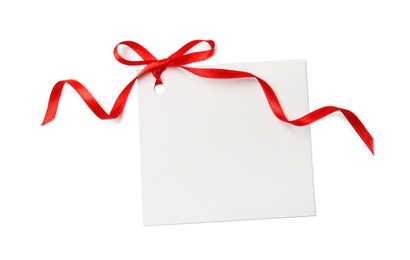 Photo of Blank gift tag with satin ribbon on white background, top view