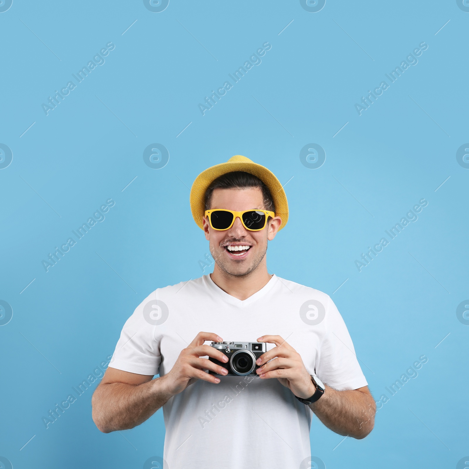 Photo of Male tourist with camera on turquoise background