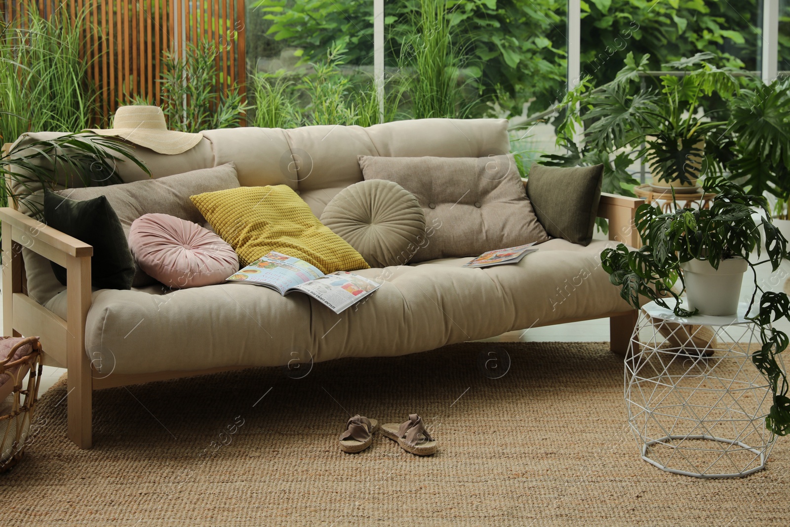 Photo of Indoor terrace interior with comfortable sofa and green plants