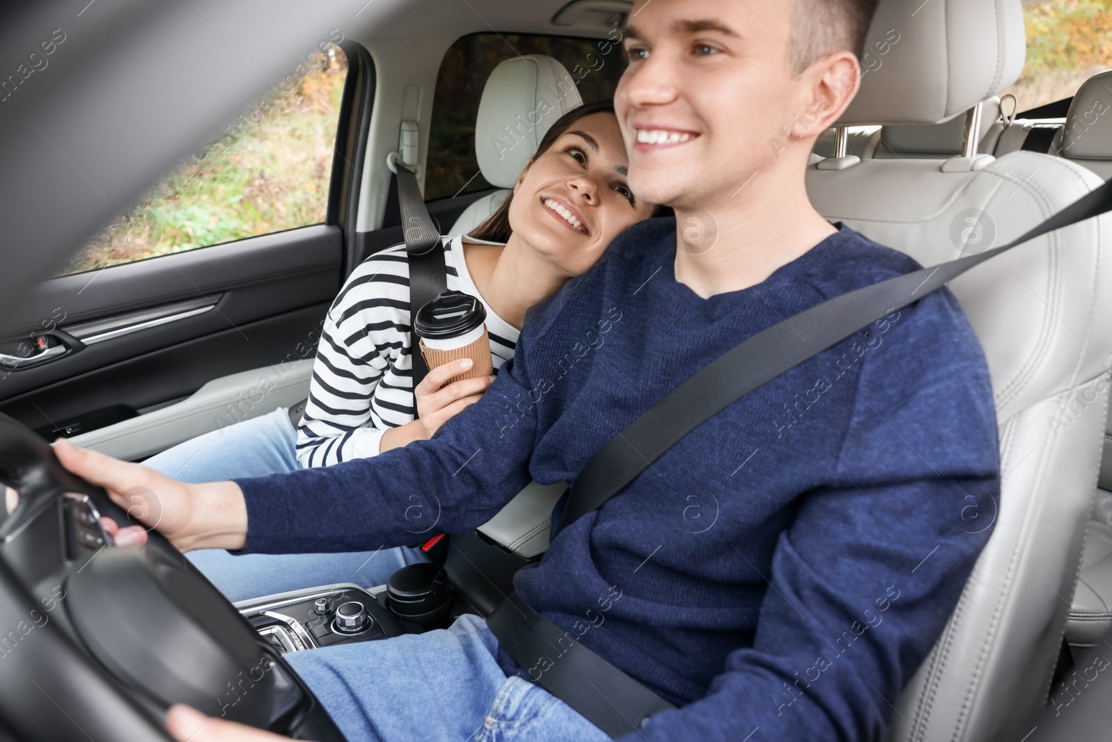 Photo of Happy young couple travelling together by car