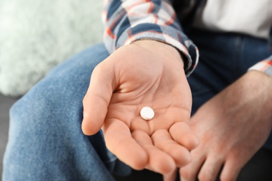 Photo of Man holding pill in hand, closeup view. Health care