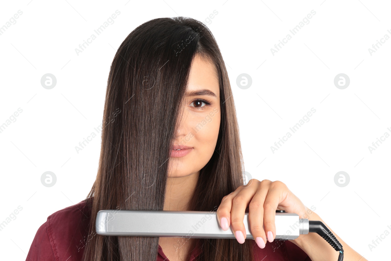 Photo of Young woman using hair iron on white background