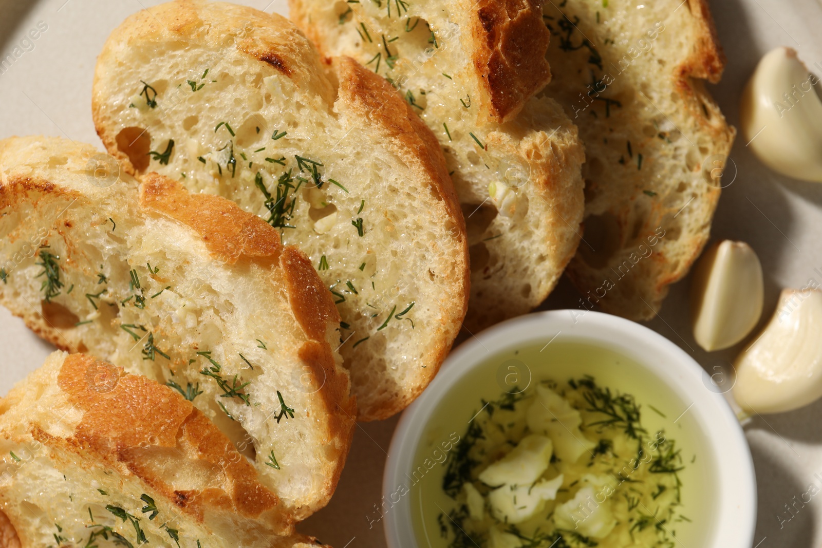 Photo of Tasty baguette with garlic and dill on table, closeup