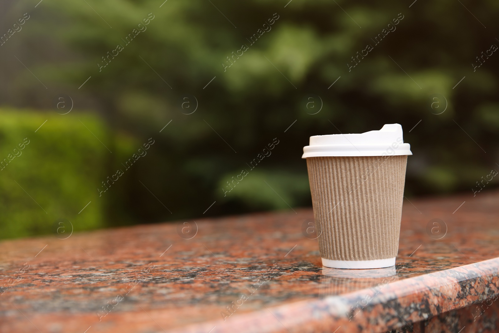 Photo of Takeaway paper coffee cup outdoors, space for text