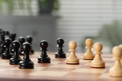 Black and white wooden pawns on chess board, closeup. Space for text