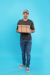 Young courier with pizza boxes on color background. Food delivery service