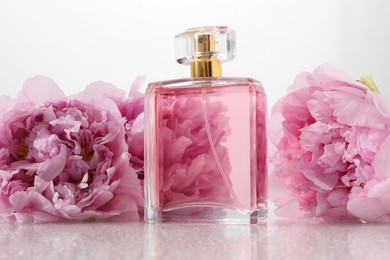 Photo of Luxury perfume and floral decor on plastic surface