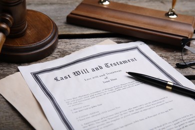 Photo of Last will and testament with pen on wooden table